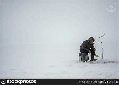 man fishing alone outside winter
