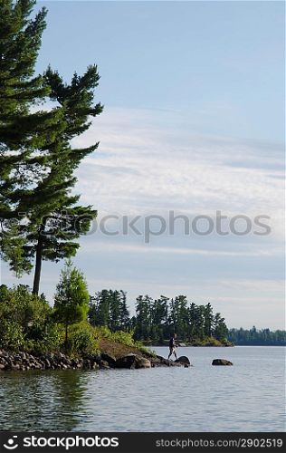 Man fishing at lakeside, Lake of the Woods, Ontario, Canada