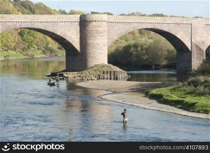 Man fishing under bridge in Berwickshire, Scotland