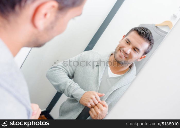 man fitting a cardigan in the changing room