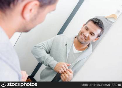 man fitting a cardigan in the changing room