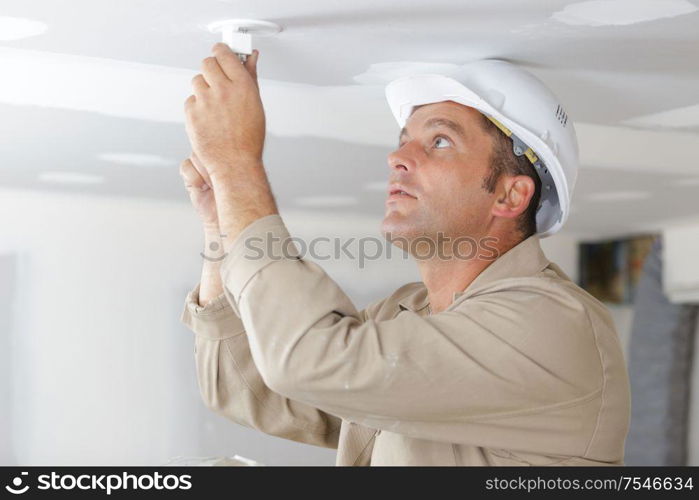 man fitting a low energy cfl light bulb
