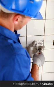 Man fitting a two pin electric socket