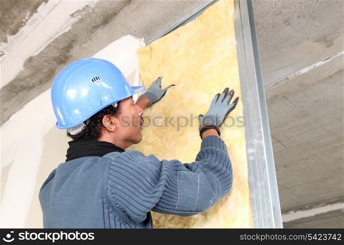 Man fitting wall insulation