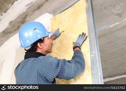 Man fitting wall insulation