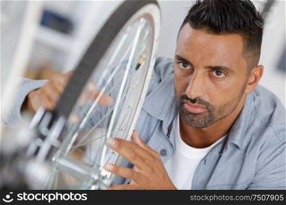 man fixing a bike wheel