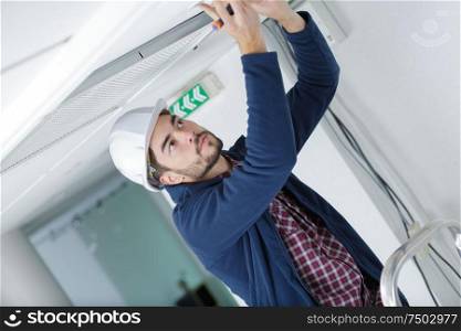man fixing light at home