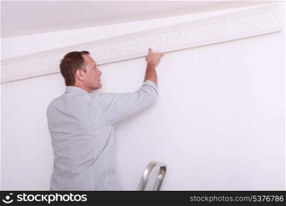 man fixing something on a wall