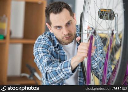 man fixing wheel on a bicycle