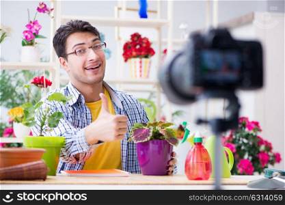 Man florist gardener vlogger blogger shooting video on camera