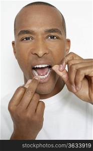 Man flossing teeth, portrait