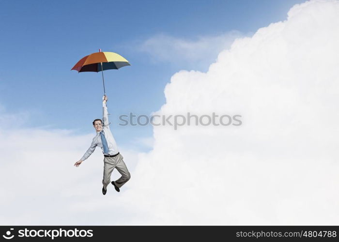 Man fly on umbrella. Young businessman flying high in sky on umbrella