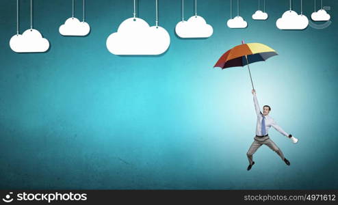 Man fly on umbrella. Young businessman flying high in sky on umbrella