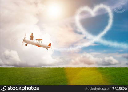 Man flying airplane and making heart shape