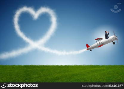 Man flying airplane and making heart shape