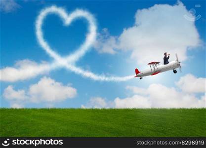 Man flying airplane and making heart shape