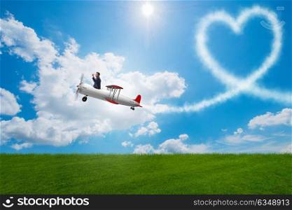 Man flying airplane and making heart shape