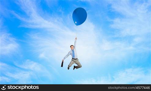 Man flying in sky. Young successful businessman flies on colorful balloon