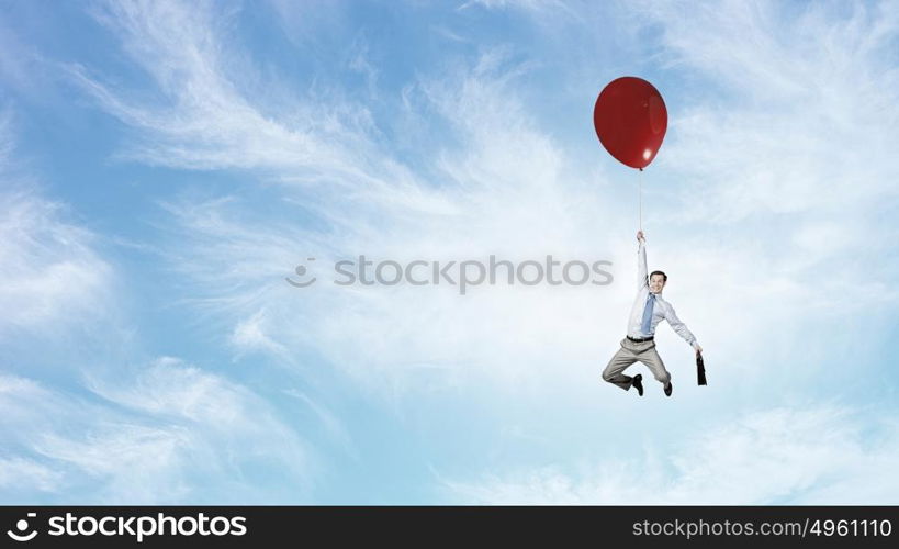 Man flying in sky. Young successful businessman flies on colorful balloon