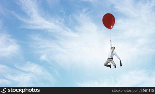 Man flying in sky. Young successful businessman flies on colorful balloon