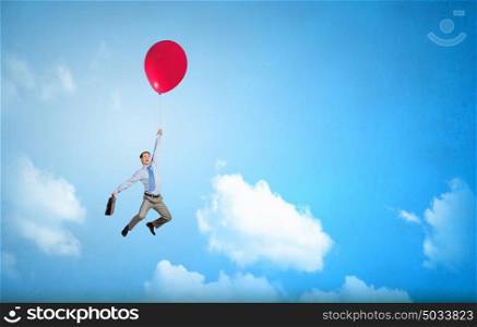 Man flying in sky. Young successful businessman flies on colorful balloon