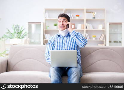 Man freelancer in a cervical collar neck brace working from home