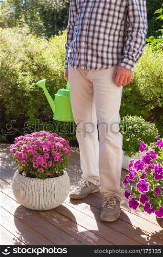 man gardener holding watering can in garden