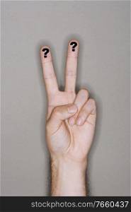 Man gesturing peace sign with question mark on finger