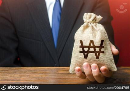 Man gives a south korean won money bag. Loan issuance. Financial support, leasing. Funding. Accounting tax payment. Earnings and profits. Investments, financing Lobbying. Stimulating economic recovery