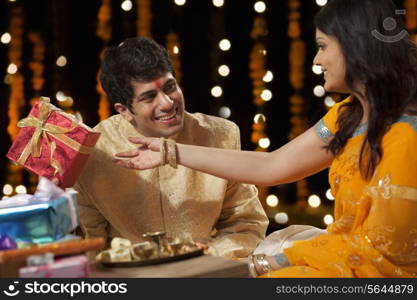 Man giving a gift to his sister