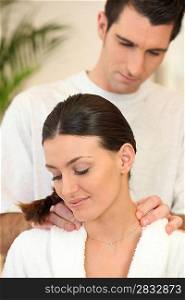 Man giving a young woman a shoulder massage