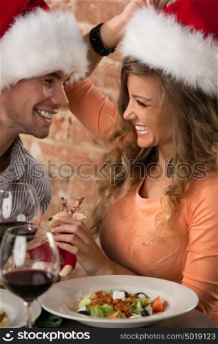 Man Giving Christmas Gift To his Woman In Restaurant