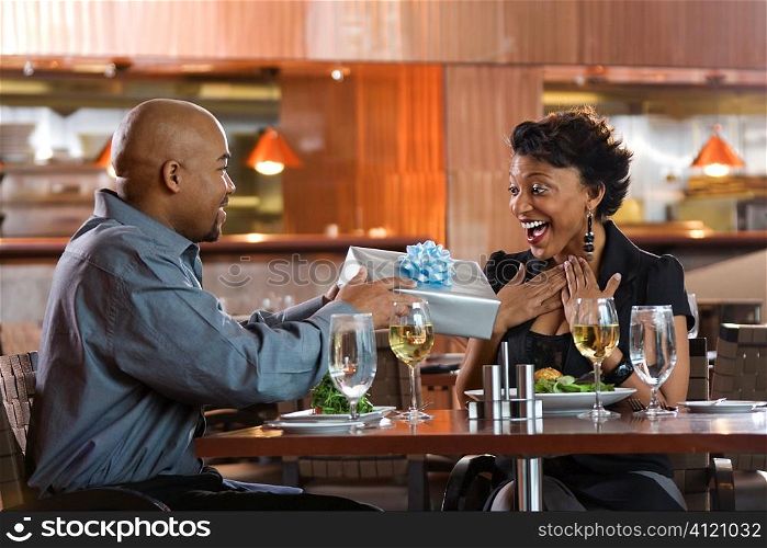 Man Giving Gift to Woman at Restaurant