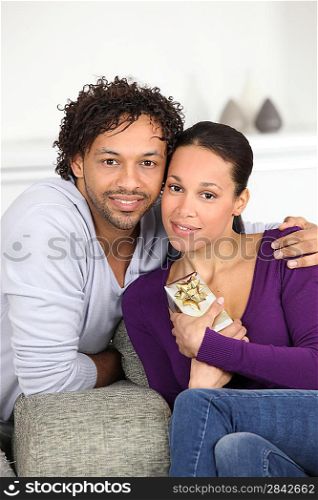 Man giving his girlfriend a gift on the sofa