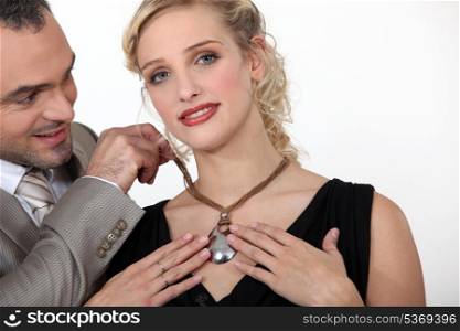 Man giving his girlfriend a necklace