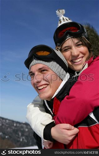 Man giving his girlfriend a piggy-back in the snow
