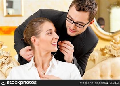 Man giving his wife a necklace as a gift