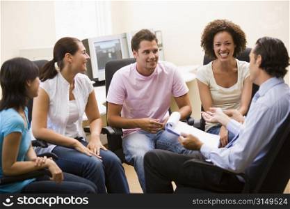 Man giving lecture to four people in computer room