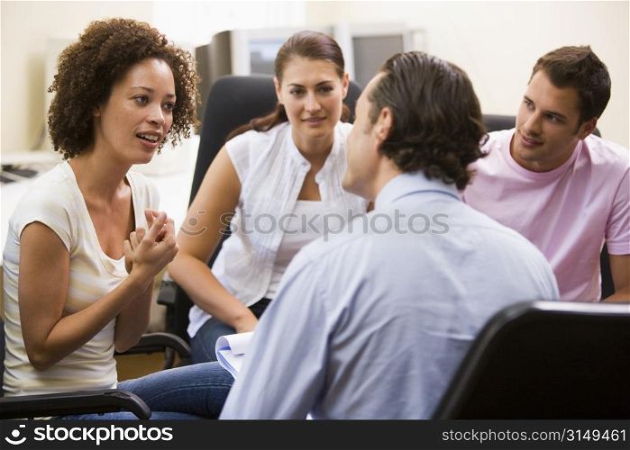 Man giving lecture to three people in computer room