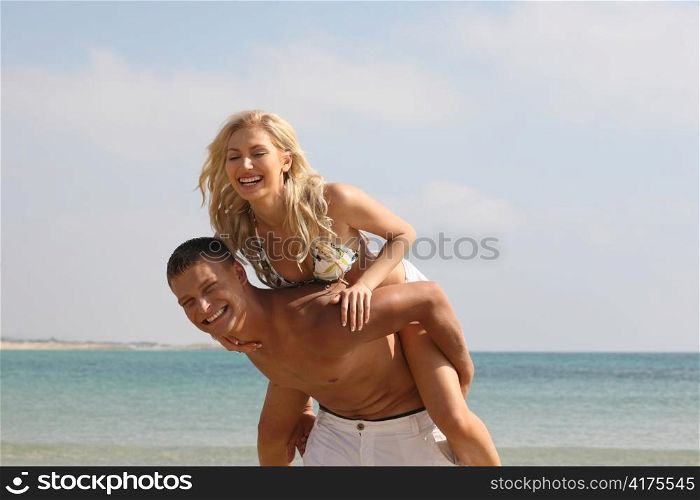 Man giving piggyback ride on the beach