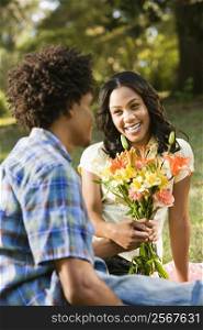 Man giving smiling woman bouquet of flowers.