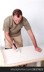 Man gluing wallpaper