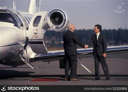 Man Greeting Businessman On Runway