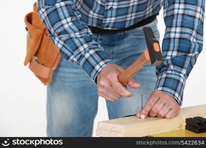 Man hammering nail into wood