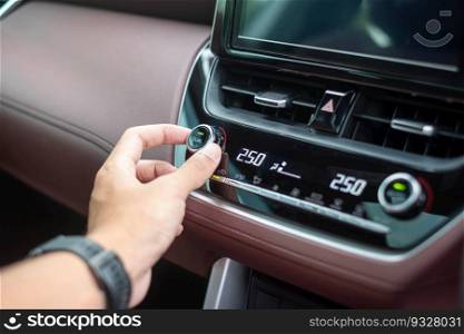 man hand adjusting temperature the air flowing during driving car on the road, air conditioner cooling system inside the car. Adjust, temperature and transport concept