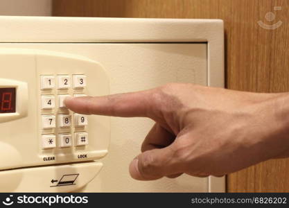 man hand entering code on keypad of safe box