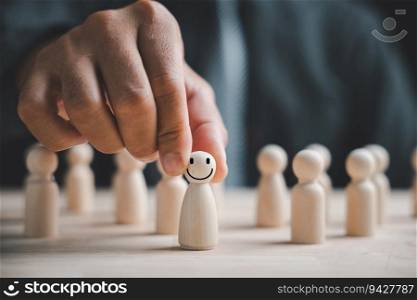 Man hand firmly holds wooden human figure. HR officer seeks leader and CEO. Leader breaks free from the crowd. Personal development, motivation, challenge. HR, HRM, HRD concepts.
