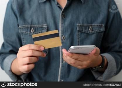 Man hand holding credit card and smart phone for shopping online concept, business, finance and technology, online payment, digital money concept