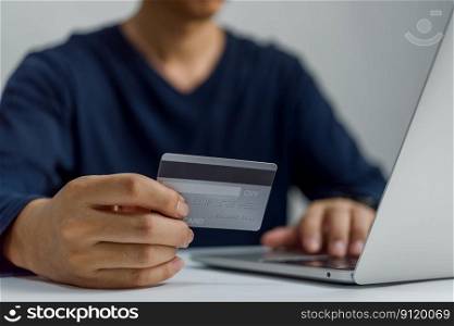 Man hand holding credit card and using laptop.Businessman or entrepreneur working , e-commerce, internet banking Online shopping.