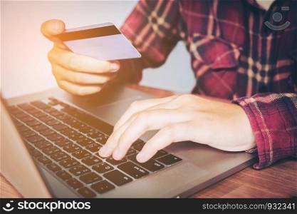 Man hand holding credit card using keyboard laptop online banking. shopping online